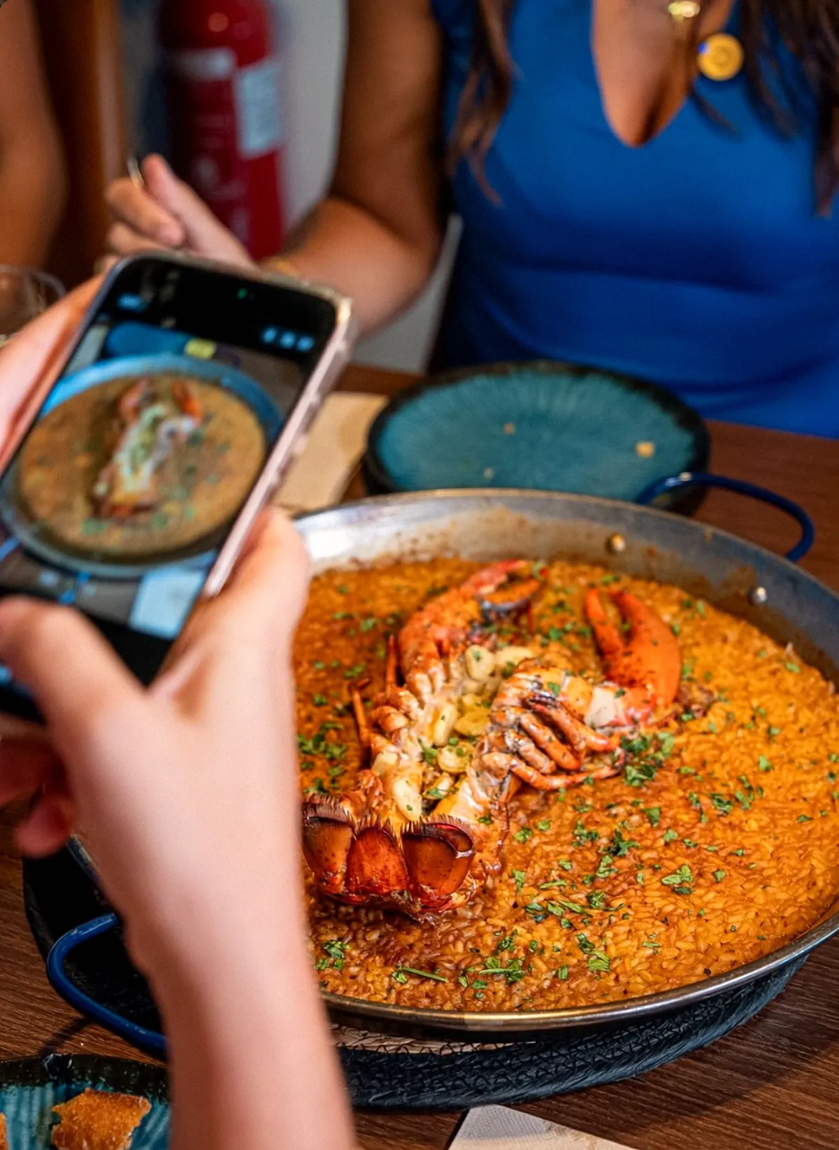 Una clienta fotografía con el móvil un arroz con bogavante